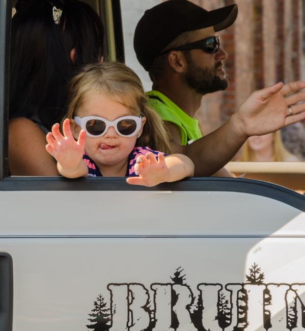 She is having a great time being in the parade and waving to everyone along the way.