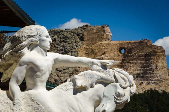 Crazy Horse. The white sculpture is the model and the background is where it is being carved from the mountain.